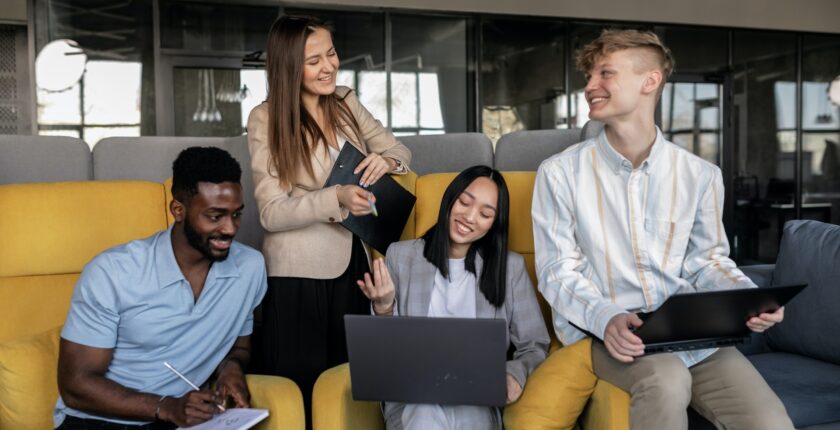 A Diverse Group Of Employees Smiling And Working Together In An Office